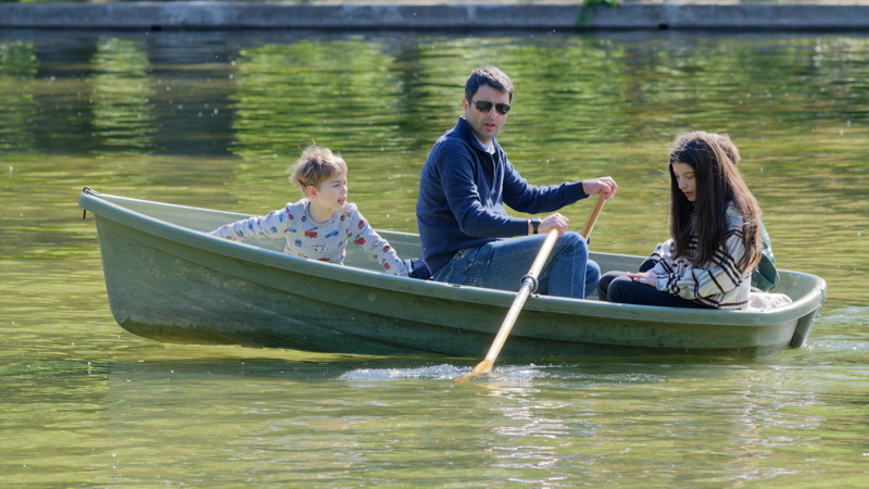 Young family in a boat on a park lake
